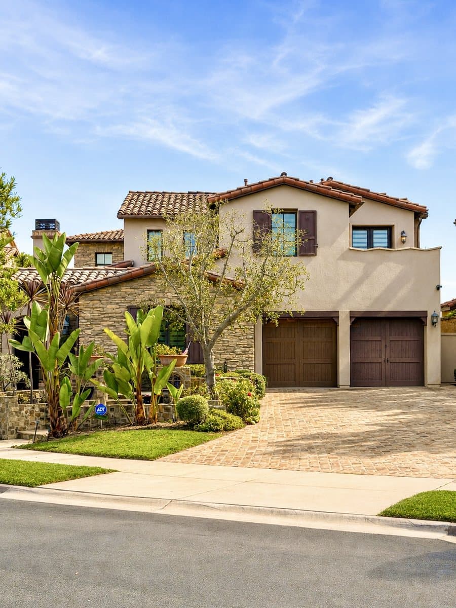 Mediterranean-style home exterior with paver driveway
