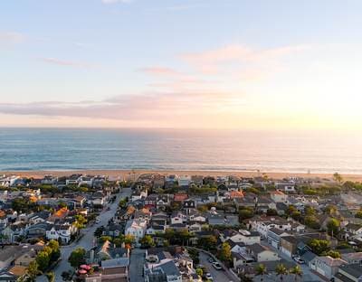 Rooftops of Peninsula Point in Newport Beach at sunset with the Pacific beyond